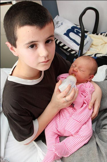 Caring ... Alfie bottle feeds his little daughter Caring ... Alfie bottle feeds his little daughter